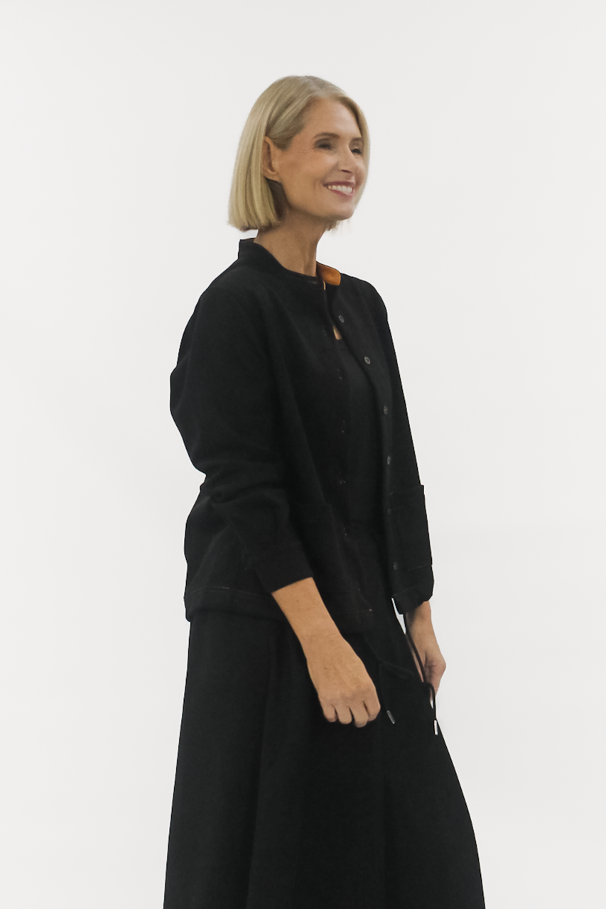 Woman wearing a black coat against a white background