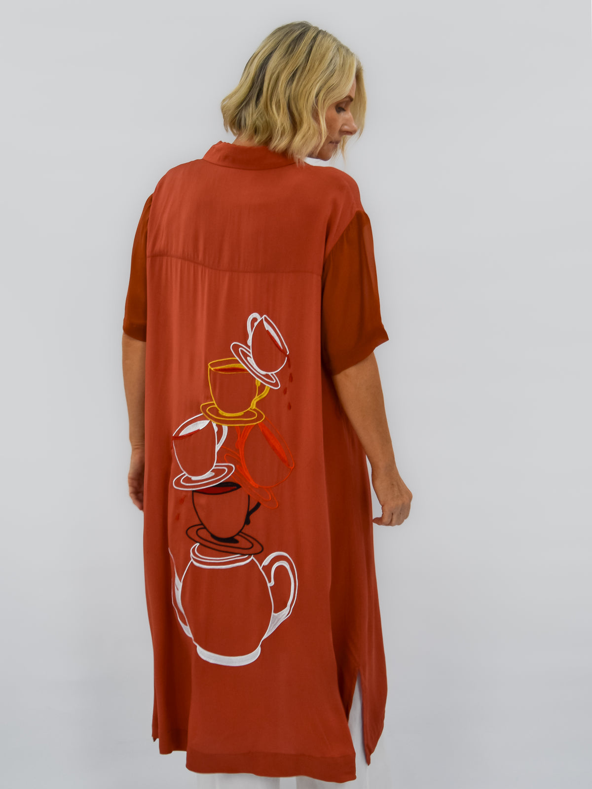 Rust orange short sleeve dress with tea cups and tea pot cascading down the back down the back 